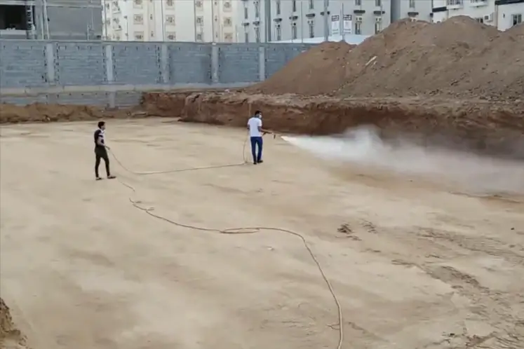 عمال شركة مكافحة العته بجدة أثناء رش البطحاء قبل البناء